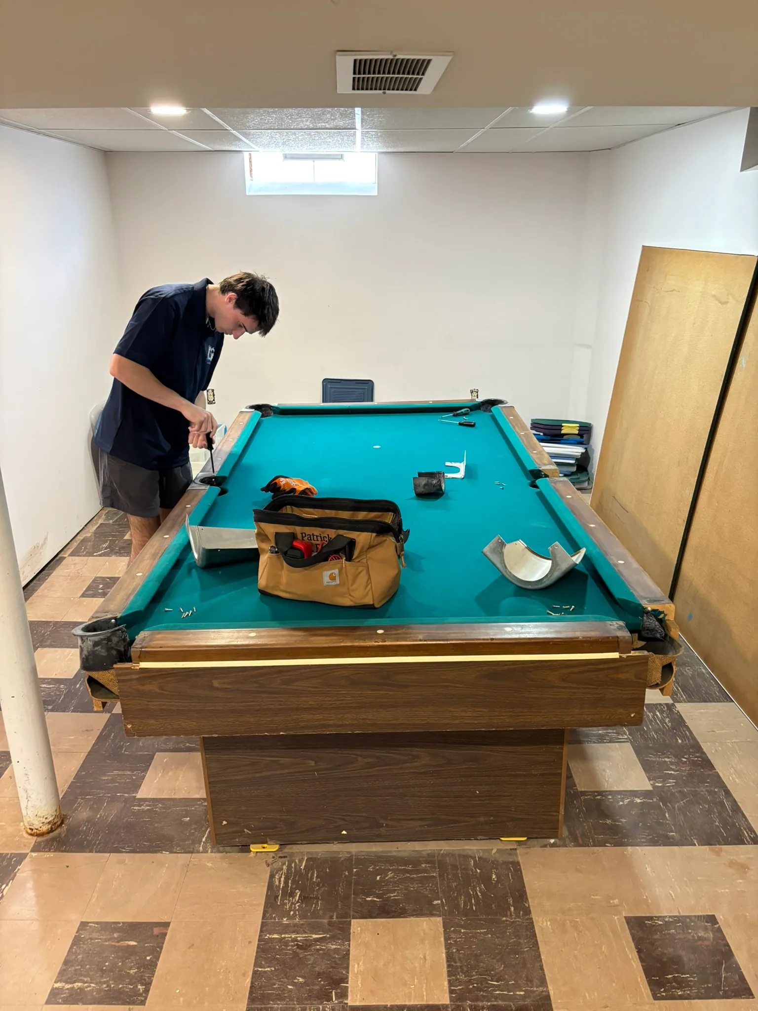 Junkernauts Junk Removal crew disassembling a pool table for removal